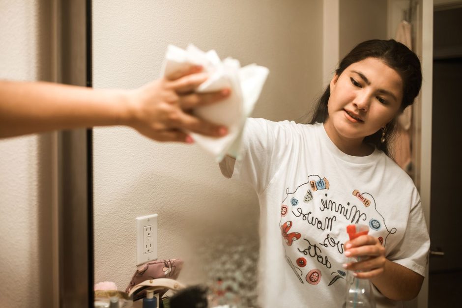 Woman wiping a wall with a cloth and spray in a bright home. Photo by RDNE Stock project on Pexels