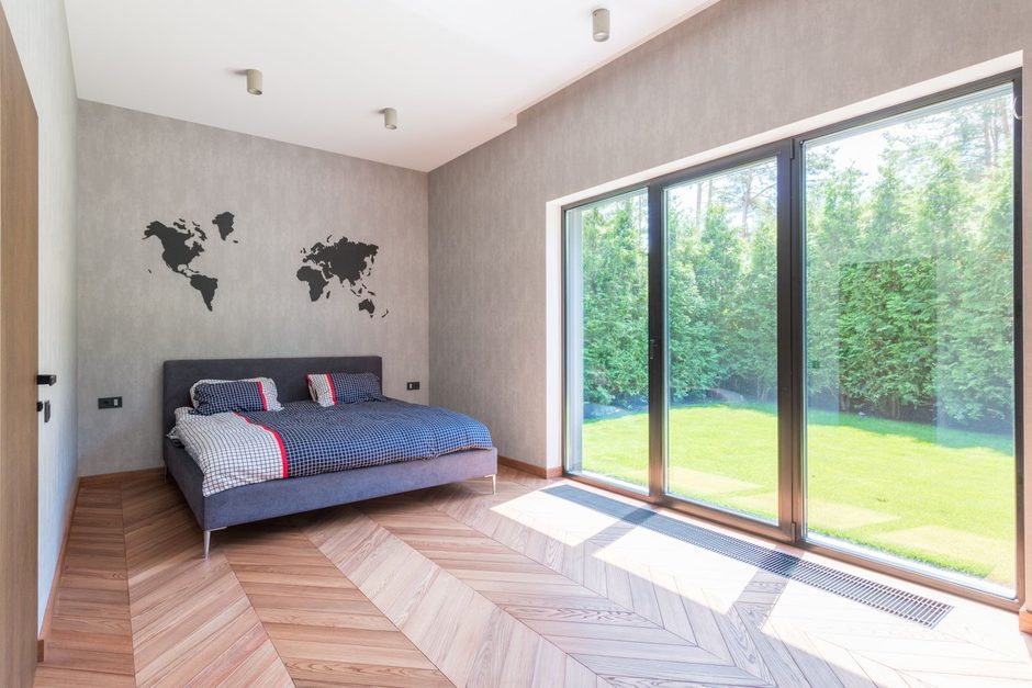 Bright bedroom in a landed house with sliding glass doors opening onto a green garden. Photo by Max Vakhtbovych on Pexels