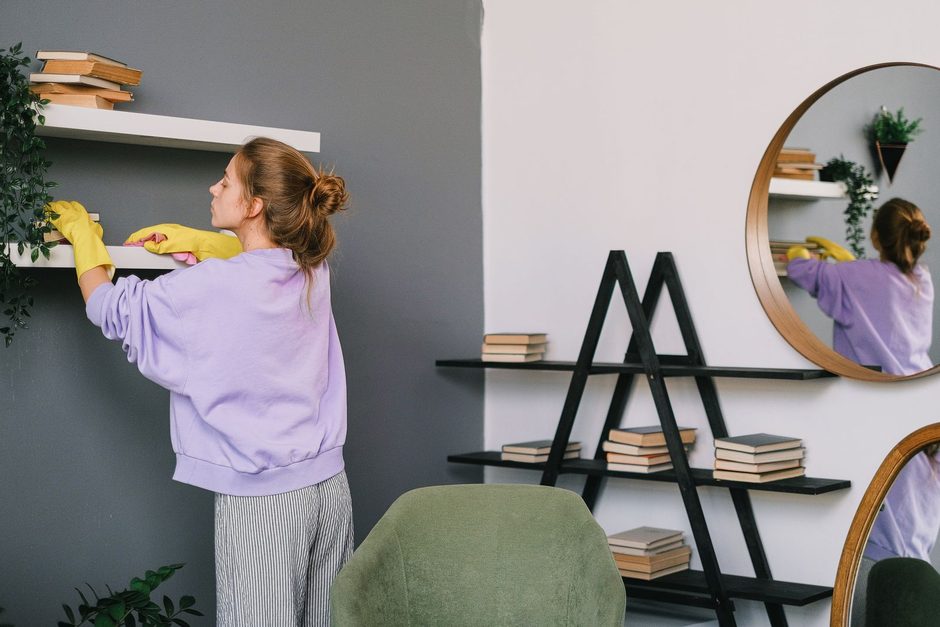 Photo by SHVETS production on Pexels Woman in purple top cleaning living room shelves and a mirror in a bright apartment. Photo by SHVETS production on Pexels